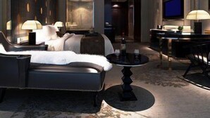 Une chambre d’hôtel moderne dotée d’un grand lit, d’un canapé, d’un coin repas et d’une télévision.