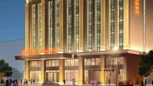 Un hôtel moderne doté d’une entrée imposante, de grandes fenêtres et d’une façade bien éclairée.