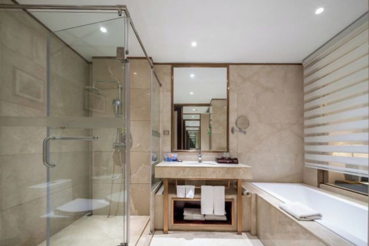 Une salle de bain moderne avec une douche à parois de verre, un meuble-lavabo avec un miroir et une baignoire.