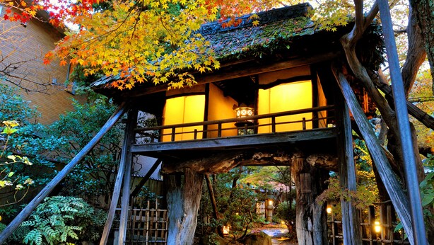 A traditional Japanese building with a wooden structure, elevated platform, and lanterns. - Heihachi Tea House Inn (Kyoto)