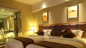 A hotel room with two beds, a glass door leading to a bathroom, and two framed pictures on the wall. - Beautiful Landscape Hotel (Liangshan Yi)