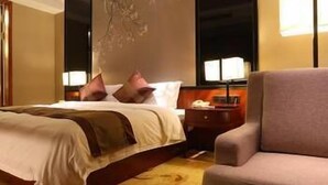 A hotel room with a large bed, a nightstand, a chair, and a large window. - Beautiful Landscape Hotel (Liangshan Yi)