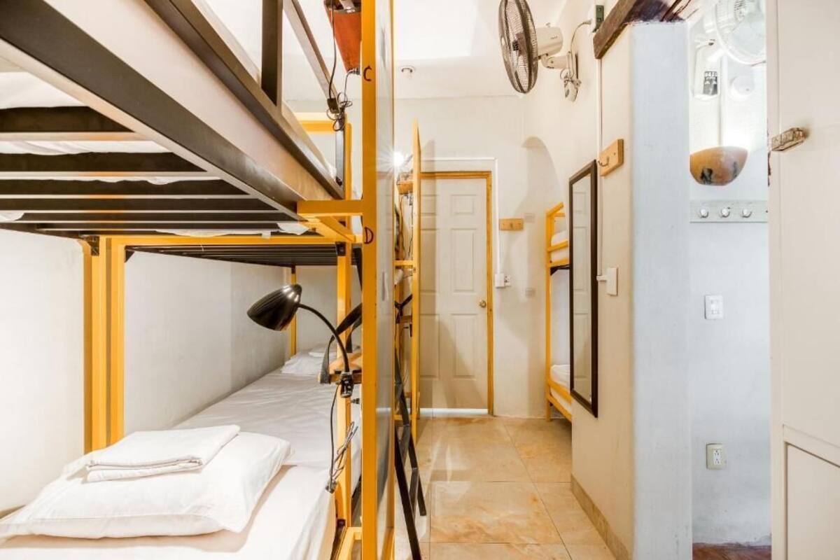 Un dormitorio con literas, un escritorio y una silla.