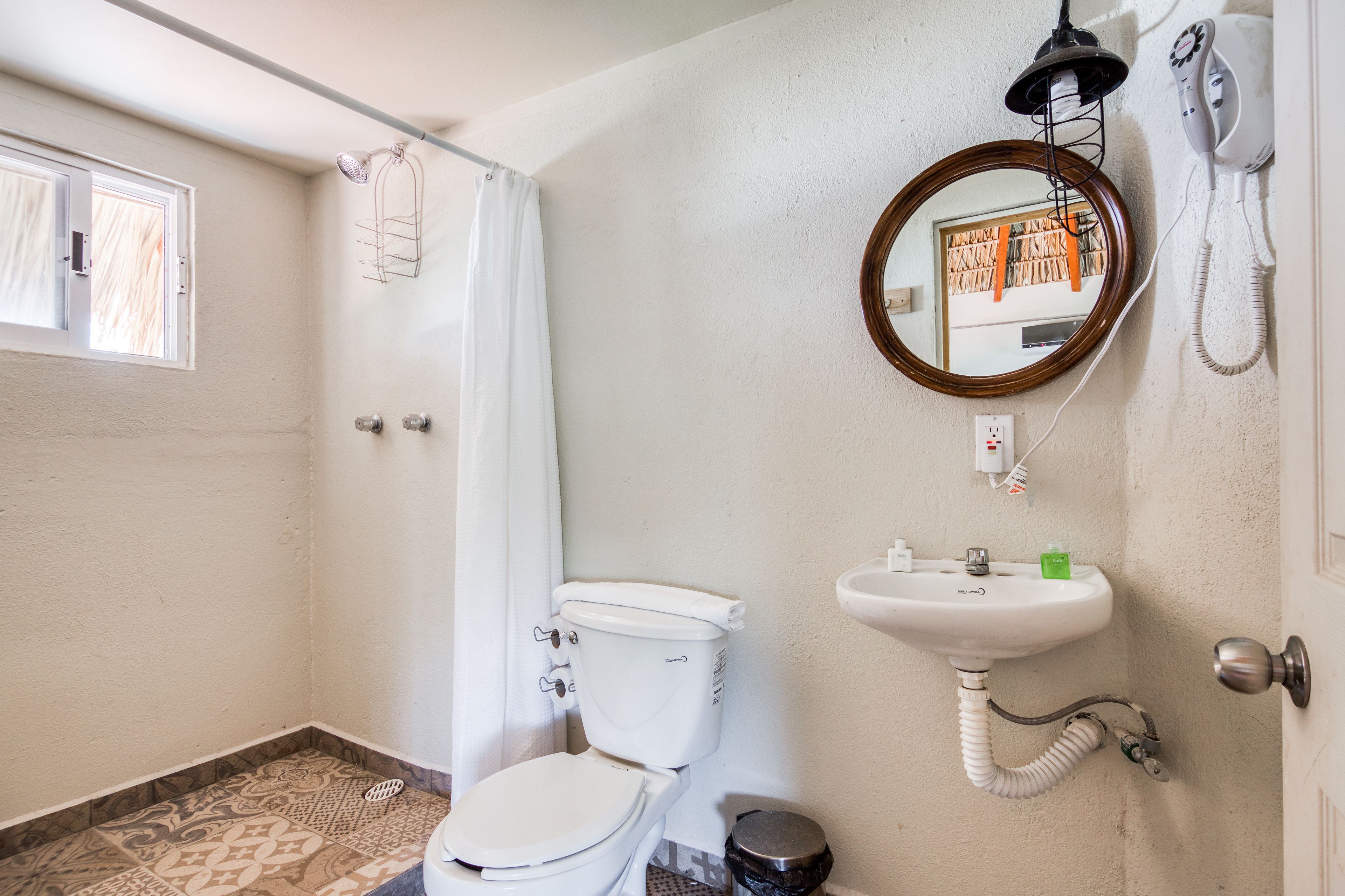 A bathroom with a toilet, sink, and shower curtain.