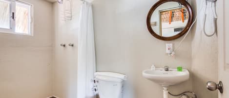 A bathroom with a toilet, sink, and shower curtain.