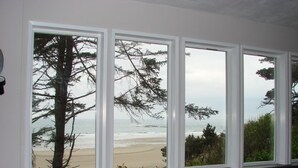 A room with a large window overlooking a beach.