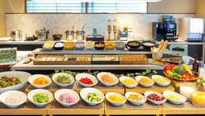 A buffet with various food items and a coffee station.