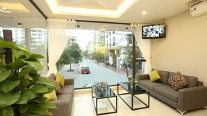 Un salón moderno con un sofá, una mesa de centro y un ventanal con vistas a la calle.