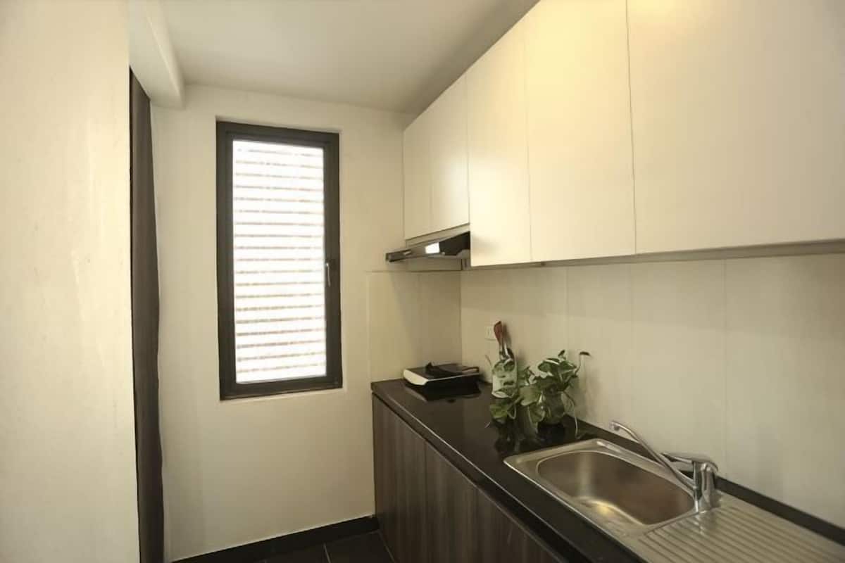 A small kitchen with a window, a sink, and cabinets.