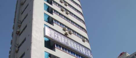 A multi-story building with signage for a hotel and a business complex.