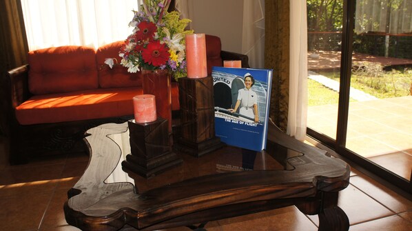 Une table basse en bois sur laquelle se trouve un livre intitulé « L’ère de l’aviation » et un vase rempli de fleurs.