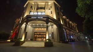 A hotel with a grand entrance, illuminated signage, and a well-lit facade. - Atour Hotel Xinzhuang Shanghai (Shanghai)