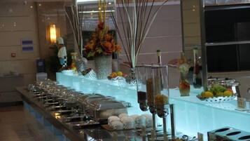 A buffet setup with various food items and a decorative centerpiece.