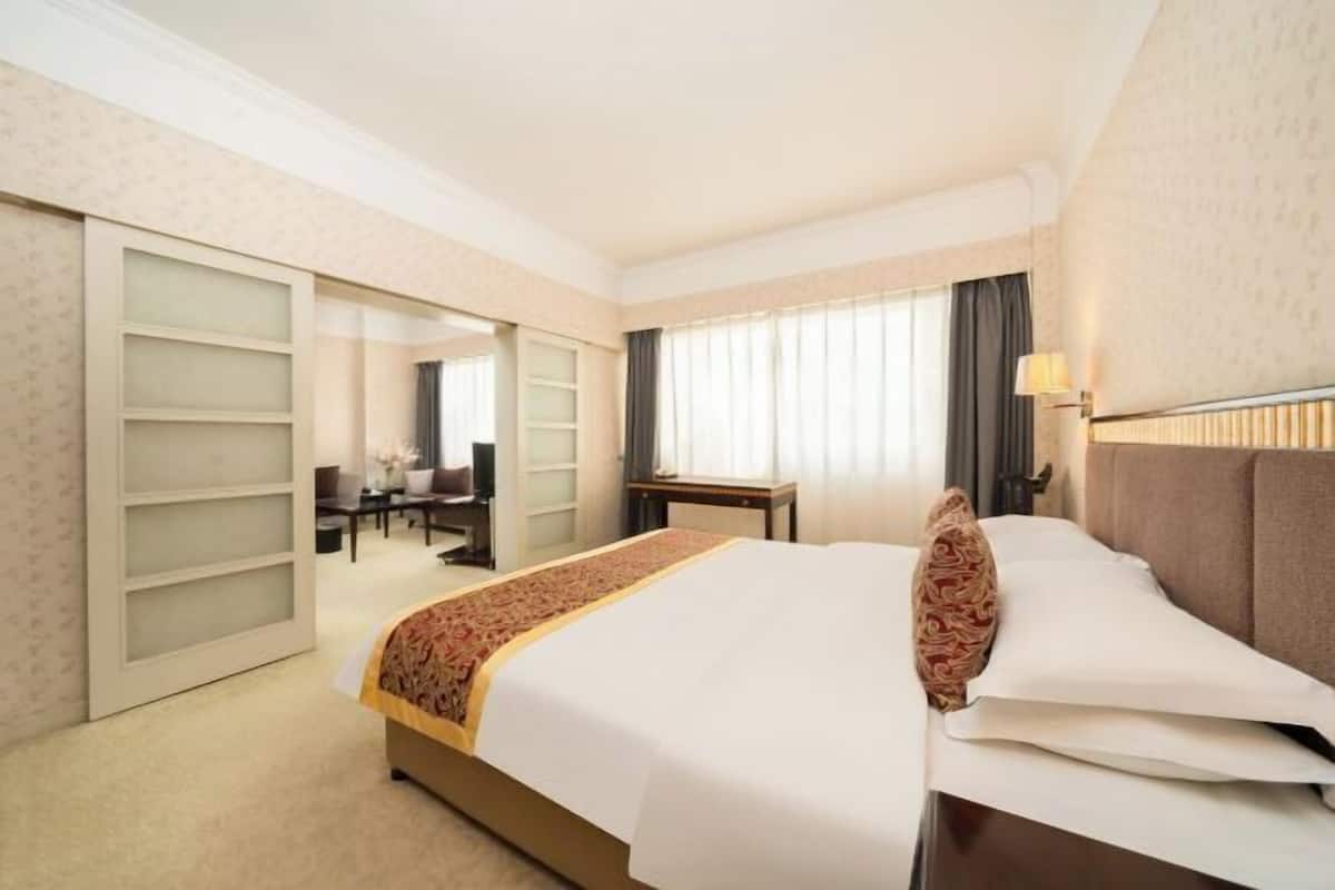 Een hotelkamer met een bed, een bureau, een stoel en een kledingkast.