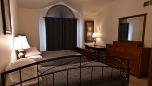 Une chambre à coucher avec un lit, un bureau, une commode et un miroir.