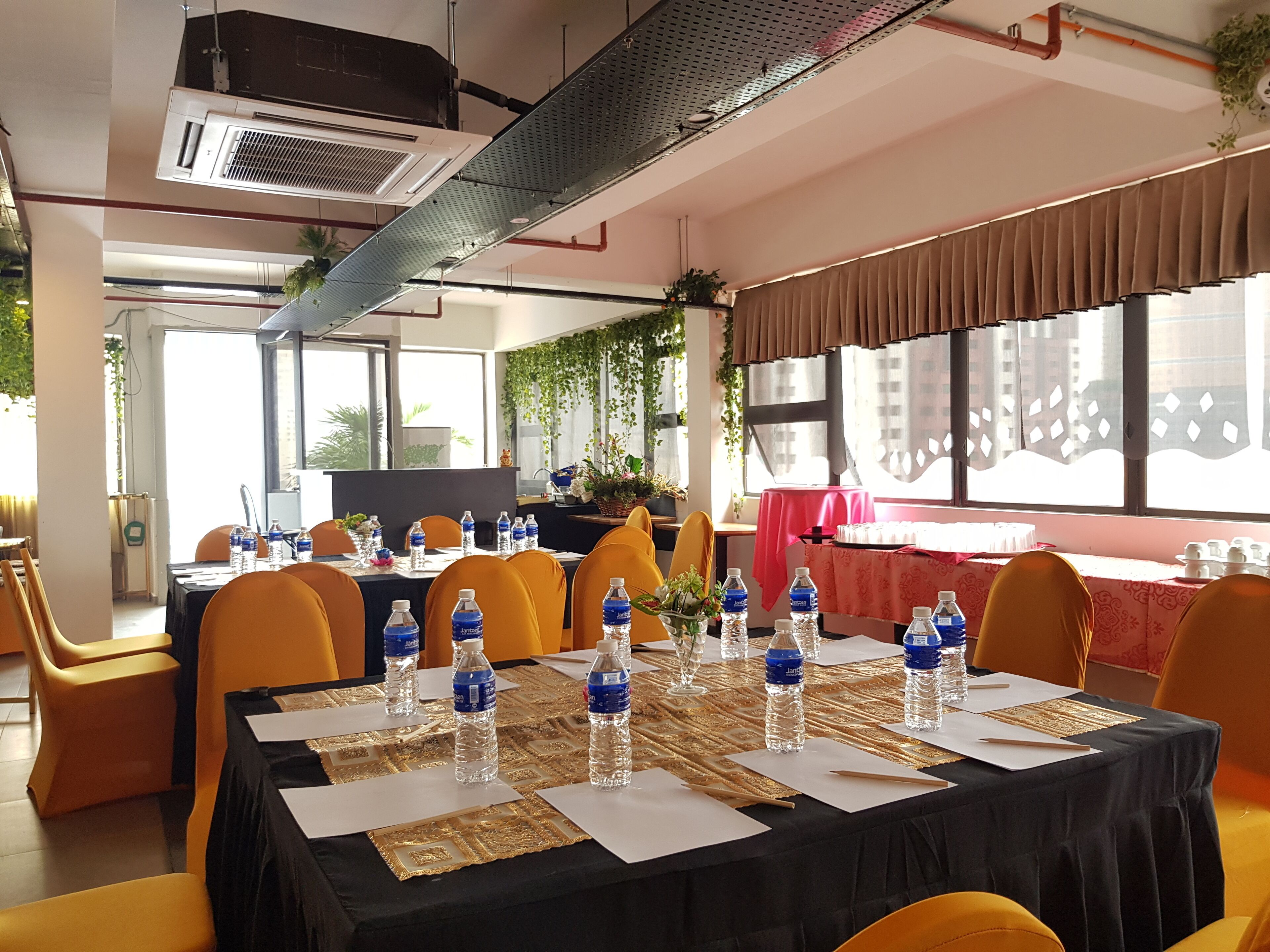 A conference room with tables set for a meeting, equipped with water bottles and name cards.
