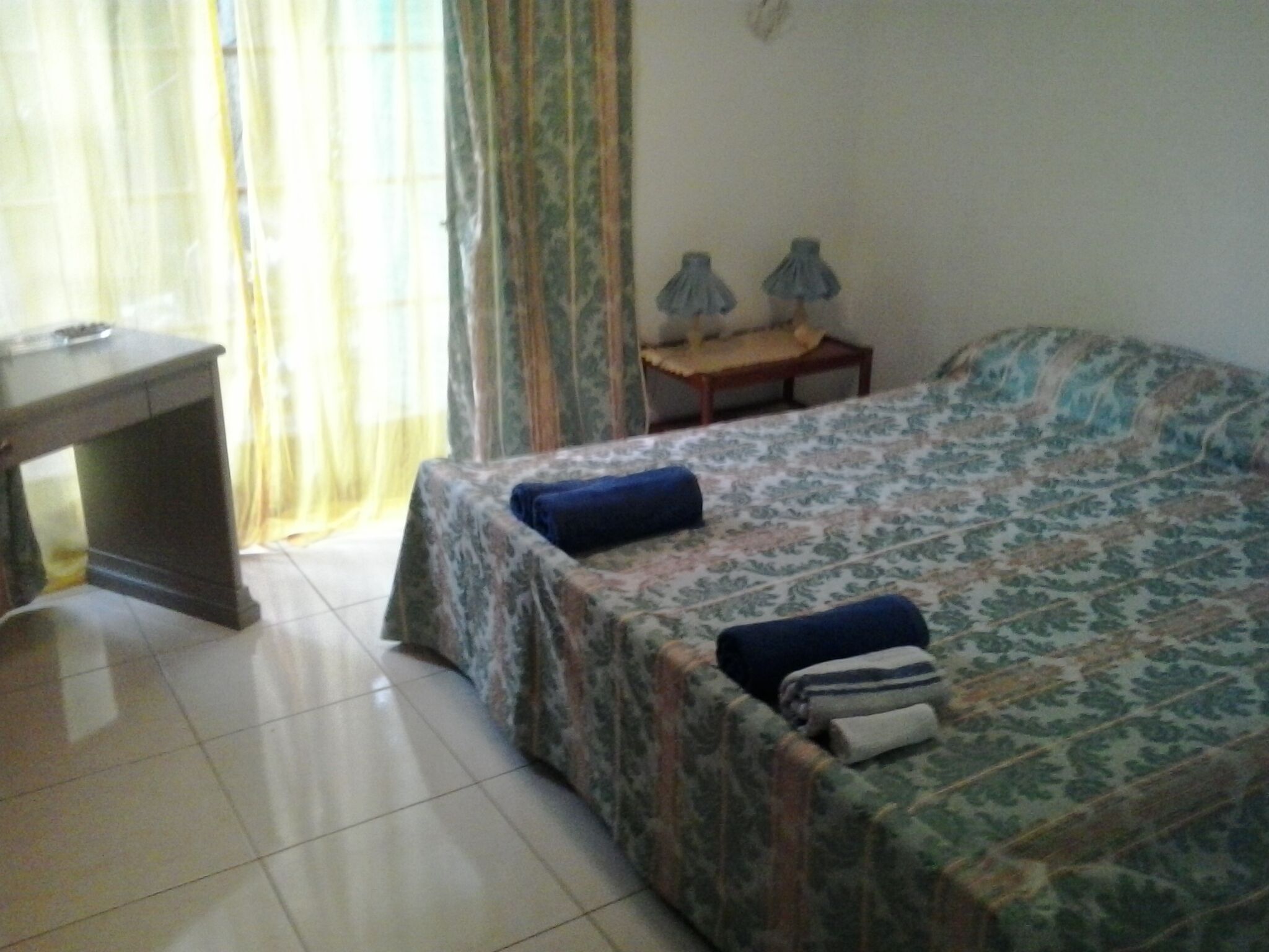 Ein Schlafzimmer mit Bett, Schreibtisch und Stuhl.
