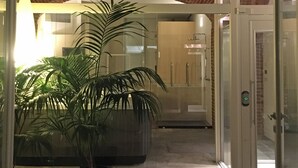 A hallway with a brick ceiling, potted plants, and a glass door leading to a room. - Alla Corte dei Bertoli SPA - Casa Gioele (Canale)