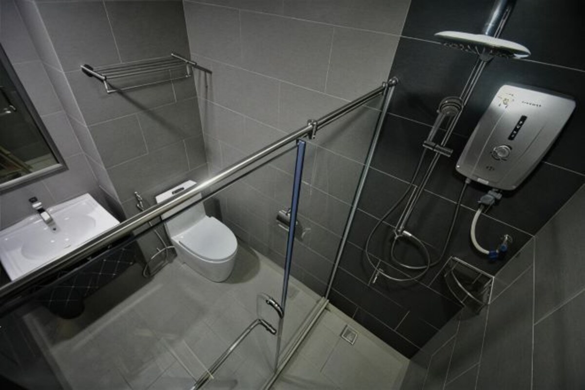 A modern bathroom with a glass shower enclosure, a toilet, and a sink.