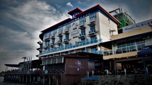 Un hotel de varios pisos con balcones, un muelle y un restaurante llamado Mermaid Inn.