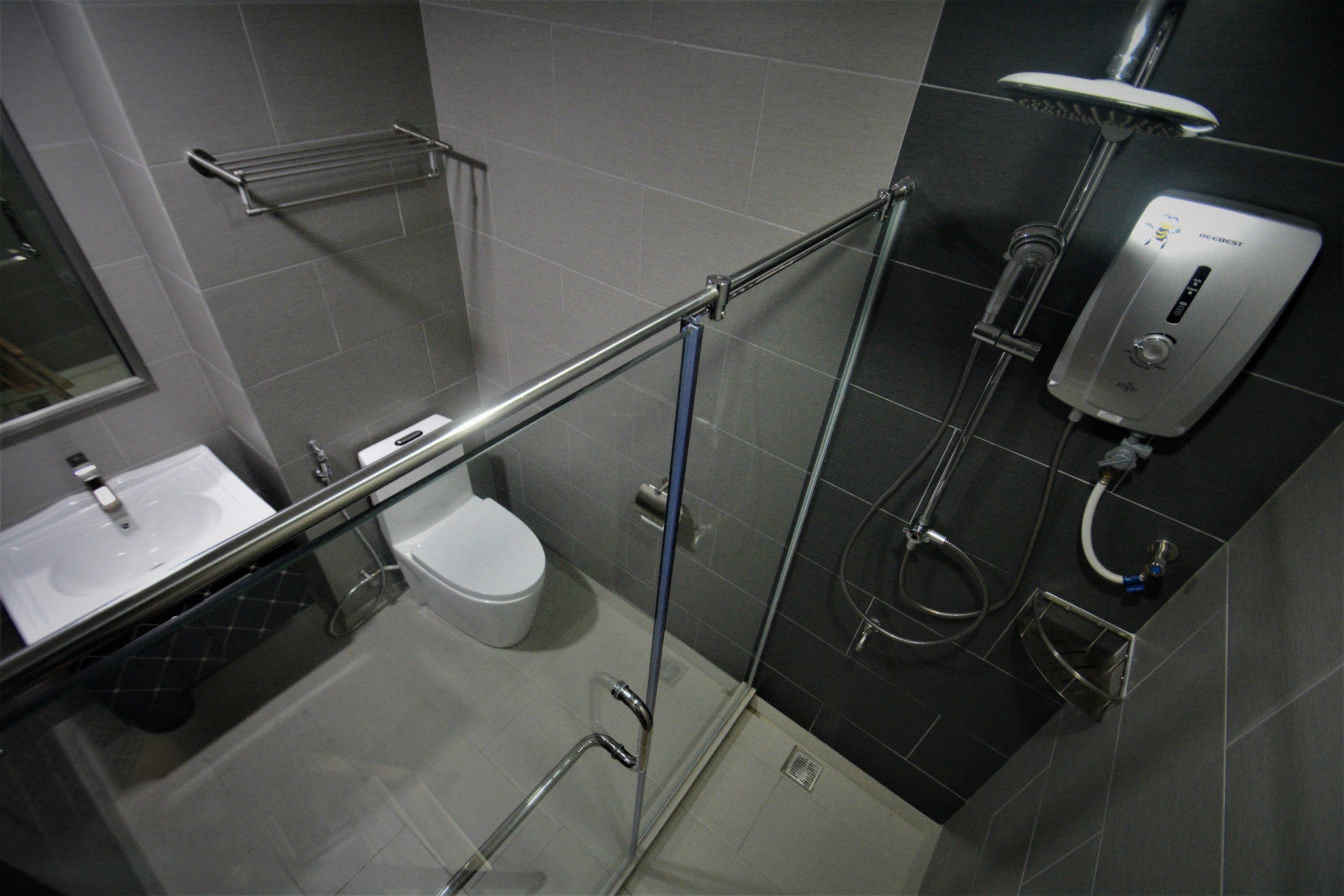 A modern bathroom with a glass shower enclosure, a toilet, and a sink.