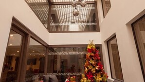 Un amplio atrio con techo alto, ventanas grandes y una lámpara moderna.