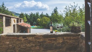 A stone wall with a bottle of wine and a glass on top. - Large stone manor with 8BR and 7BA, extended grounds, large fully-equipped pool. (CORTONA)
