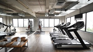 A gym with treadmills, exercise bikes, and weights. - Hotel Monopoli (Jakarta)
