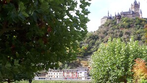 A parking area with cars, a paved walkway, and a building with multiple windows in the background. - Pension Elisabeth (Cochem)