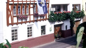 A traditional half-timbered building with a flag, flower boxes, and a sign indicating a restaurant. - Pension Elisabeth (Cochem)