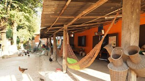 A rustic outdoor area with a wooden structure, hammocks, and traditional pottery. - Ram Yai Homestay - Hostel (Sukhothai)