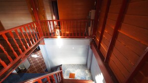 A wooden staircase with red railings leading to a landing. - Ram Yai Homestay - Hostel (Sukhothai)