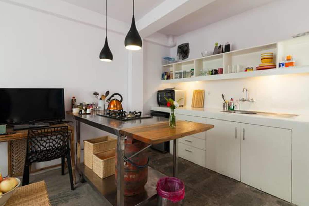 Una cocina moderna con televisión, mesa de comedor y zona de bar.