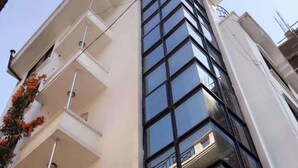 A modern building with a white facade, multiple balconies, and large windows. - Four Red Doors Apartments (Kathmandu)