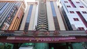 A multi-story building with a central tower, featuring a sign for a theater and a sign for a motel. - Couple Motel (Seoul)