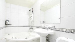 A bathroom with a bathtub, a sink, and a toilet. - Couple Motel (Seoul)
