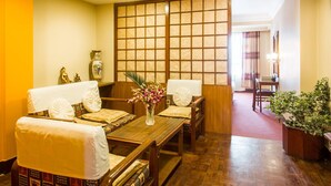 Una habitación tradicional japonesa con suelo de tatami, una mesa de madera baja y un divisor de fusuma.