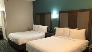 A hotel room with two single beds, a bedside table with a phone, and a carpeted floor. - FairBridge Inn Express Memphis (Memphis)