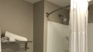 A bathroom with a shower, toilet, and towel rack. - FairBridge Inn Express Memphis (Memphis)