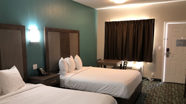 A hotel room with two beds, a desk, a chair, a telephone, and a door. - FairBridge Inn Express Memphis (Memphis)