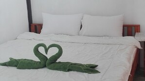 Una cama con una colcha blanca y dos almohadas.