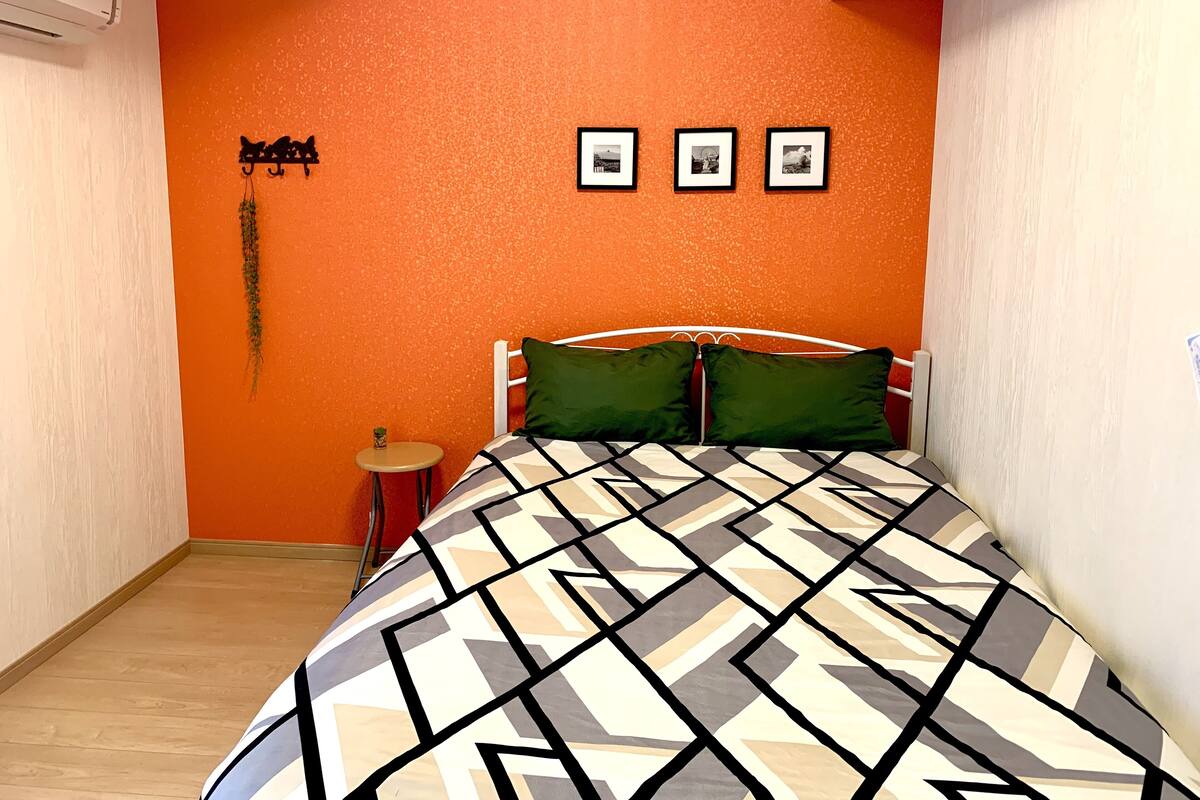 Una camera da letto con un letto, un tavolino rotondo e tre quadri appesi al muro.