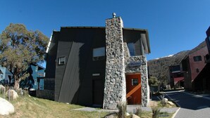 A modern building with a stone facade and a distinctive geometric pattern on the side. - Powder 2a (Thredbo)