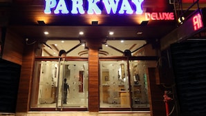 A hotel entrance with a 'PARKWAY DELUXE' sign, wooden facade, and glass doors. - Hotel Parkway Deluxe (New Delhi)