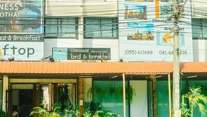 Un edificio con varios letreros que anuncian una casa de huéspedes, incluyendo información de contacto y una página web.