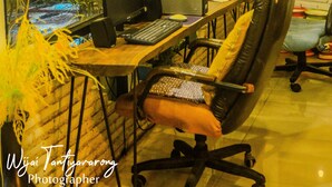 Un espacio de trabajo con dos escritorios, computadoras y sillas.