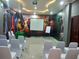 A conference room with white chairs, a whiteboard, and a projector.