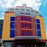A multi-story hotel with a prominent 'VENIA HOTEL' sign at the top.