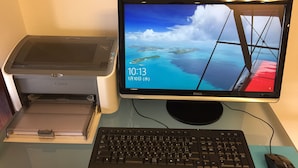 A desktop setup with a printer, monitor, keyboard, and mouse on a desk. - Hotel Town Nishikigawa (Kochi)