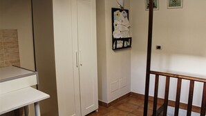 A room with a white wardrobe, a bulletin board, and a small table. - Guest House La Casetta (Piazza Armerina)